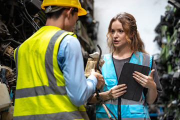 Obraz premium Portrait Caucasian woman and Asia man engineer or mechanic use tablet computer checking auto part or car part at car part warehouse 
