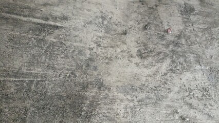 Weathered Concrete Surface with Dark Stains. Close-up of a worn concrete surface with natural stains, rough marks, and subtle texture ideal for backgrounds or material references
