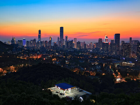 Panoramic skyline of Dalian, China, featuring skyscrapers and hills during the blue hour.