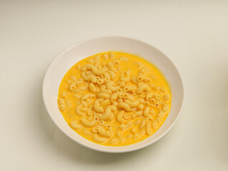 Macaroni and cheese soup in white plate
