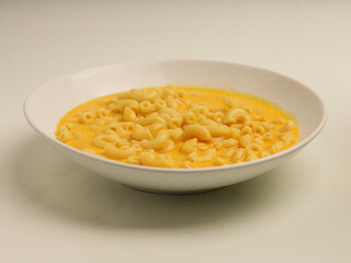 Macaroni and cheese soup in white plate