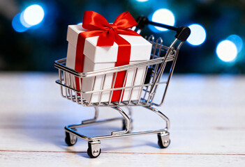 Tiny shopping cart with gift box is festive for holiday poster flyer greeting card or marketing campaign