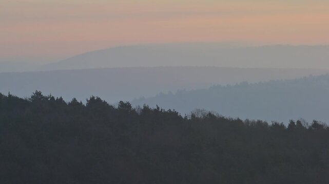 Pastellfarbene Silhouetten von H&uuml;geln und B&auml;umen bei Sonnenuntergang vermitteln eine ruhige Atmosph&auml;re, Seckmauern, L&uuml;tzelbach, Maintal, Odenwald, Hessen, Deutschland