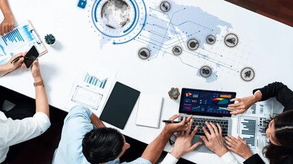 A modern business meeting scene featuring a collaborative team analyzing data on laptops, with digital visualizations overlaying a world map, highlighting teamwork and technology. Raster - Powered by Adobe