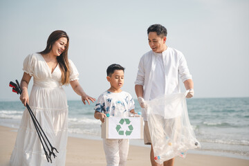 family, conservation, environmental, clean, beach, holiday, asian, A family works together to collect plastic waste on the beach, promoting environmental responsibility and care for nature.