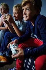 Obraz premium Video games, friends and teens on sofa in home for playing, competition and online entertainment. Challenge, living room and boys with controller for gaming, esports and winning on weekend together