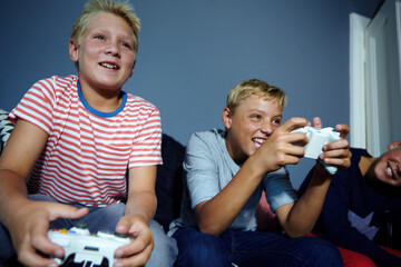 Video game, competition or siblings in home with controller, contest or playful challenge in multiplayer. Low angle, children or family on sofa with tech, bonding or console match in virtual activity
