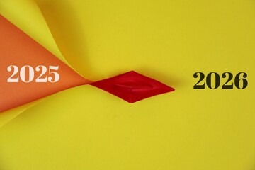 A yellow backdrop features a orange folded shape meeting a red origami boat, representing the...