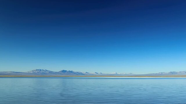 Stunning reflection of mountains and sky on a calm salt flat during midday under bright blue skies