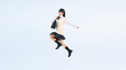 元気にジャンプする制服を着た女子学生の全身写真