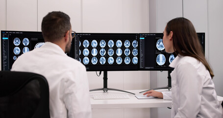 Male Neurologist Monitoring Brain Scan On Computer Screen In Clinic