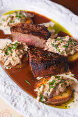 Pepper steak grilled with potatoes, mushroom julienne and three sauces