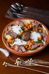 The Kazakh national dish Beshbarmak consists of boiled dough, meat and vegetables, sprinkled with sour cream.