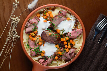The Kazakh national dish Beshbarmak consists of boiled dough, meat and vegetables, sprinkled with sour cream.