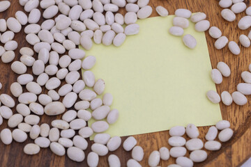White beans on wooden table with empty note space - food mockup background