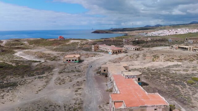 Aerial drone shot moving out over the abandoned Abades Leper Colony ruins and sanatorium towards the deep blue Atlantic Ocean in Tenerife, Canary Islands, Spain.