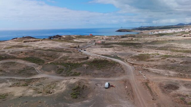 Drone flight path approaching the eerie, abandoned Abades Leper Colony and Sanatorium ruins on the arid coast of Tenerife, Canary Islands, Spain.