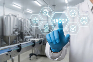 Industrial engineer touching digital HACCP interface screen in stainless steel food processing plant with automated machinery and quality assurance icons