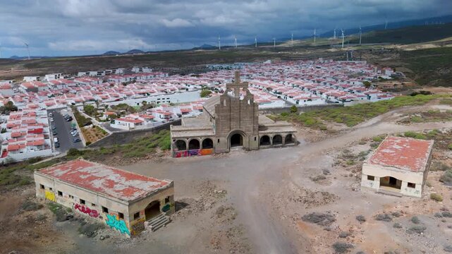 Aerial drone view circling the iconic church structure within the vast abandoned Leper Colony (Sanatorio de Abades) complex in Tenerife, Canary Islands, Spain.