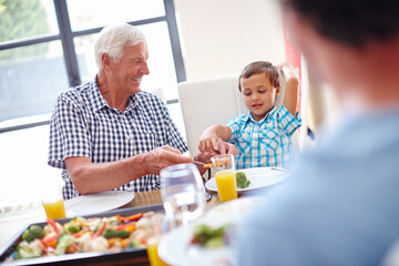 Grandfather, child and smile with family at lunch for bonding, nutrition and thanksgiving event. Vegetables, boy and social gathering with dad in dining room in home for love, celebration and brunch