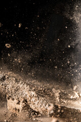 Rocks shattering, sand and gravel flying, dust billowing background