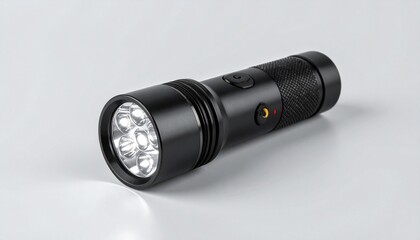 Black LED flashlight on light gray surface.