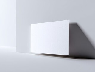 Fototapeta premium Minimalist graphic of a white paper leaning against a wall. Gentle shadow play and clean lines