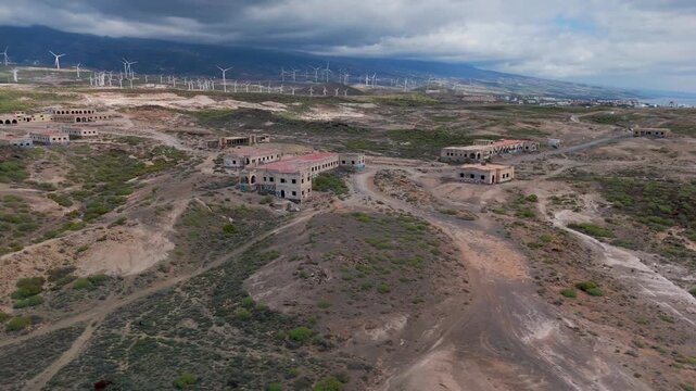Wide aerial panning shot over the vast, desolate ruins of the abandoned Sanatorio de Abades Leper Colony complex in Tenerife, Spain.