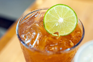 Iced Lemon Tea, Refreshing iced drink with lime slice in clear glass, close-up, highlighting bright colors and cool textures