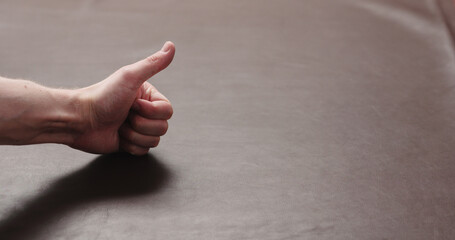 man hand checking brown leather piece closeup