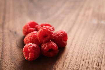 ripe raspberry on a walnut wood background with copy space