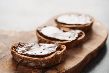 Ciabatta slices with chocolate spread on olive wood board