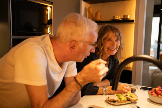 Happy senior couple sharing a loving moment while having a healthy breakfast at home