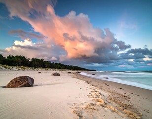 Sandy beach with big rocks, long exposure and cloud formations