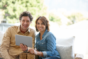 Tablet, relax and portrait of couple on sofa in home for social media, communication or contact on app. Happy, bonding and married people for message on digital technology in living room at house.