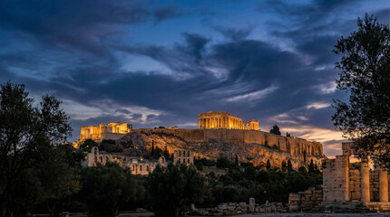 Fototapeta premium Stunning view of the Acropolis at sunset, showcasing dramatic clouds and ancient ruins, perfect for travel brochures or cultural articles.