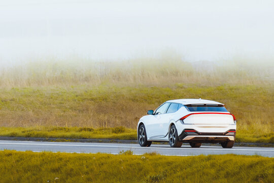 Fototapeta Stylish white SUV crossing countryside