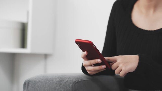 部屋でスマホを使う女性