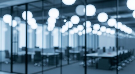 Blurred view of a modern office interior with glass partitions and numerous bright spherical ceiling lights creating a bokeh effect in cool blue tones