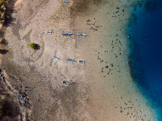 Boats in harbor with blue ocean in Bali. Drone view.