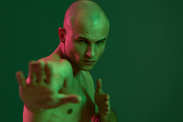 Athletic man posing dynamically in a dramatic green lighting, showcasing strength and determination...