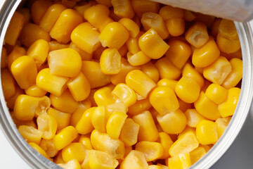 A can of corn is opened and the corn is yellow