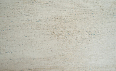 Fototapeta premium Craquelure.A photo of the texture of old white paint with cracks.Shabby chic background on a wooden surface.