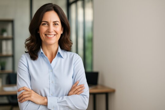 Confident woman smiling with arms crossed in a professional office setting. - Powered by Adobe