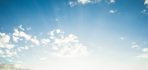 the sky is full of white clouds, bright blue, and beautiful sunlight.