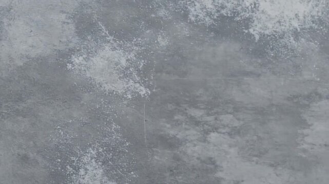 A textured gray background displaying an abstract pattern of mixed shades and visible brushstrokes