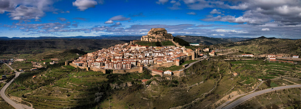 Morella, Spain medieval walled city and castle on a hilltop, surrounded by green landscape under blue sky