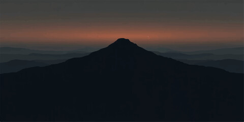 Silhouetted mountain peak at sunset with a dark and moody sky