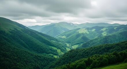 Fototapeta premium Vast, panoramic view of rolling green mountains under a dramatic, cloudy sky