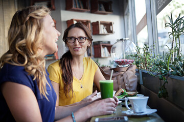 Relax, friends and women in restaurant in conversation for bonding, social reunion and hangout together. Laugh, cafeteria and people with drink, food and chat for talking, gossip and lunch on weekend